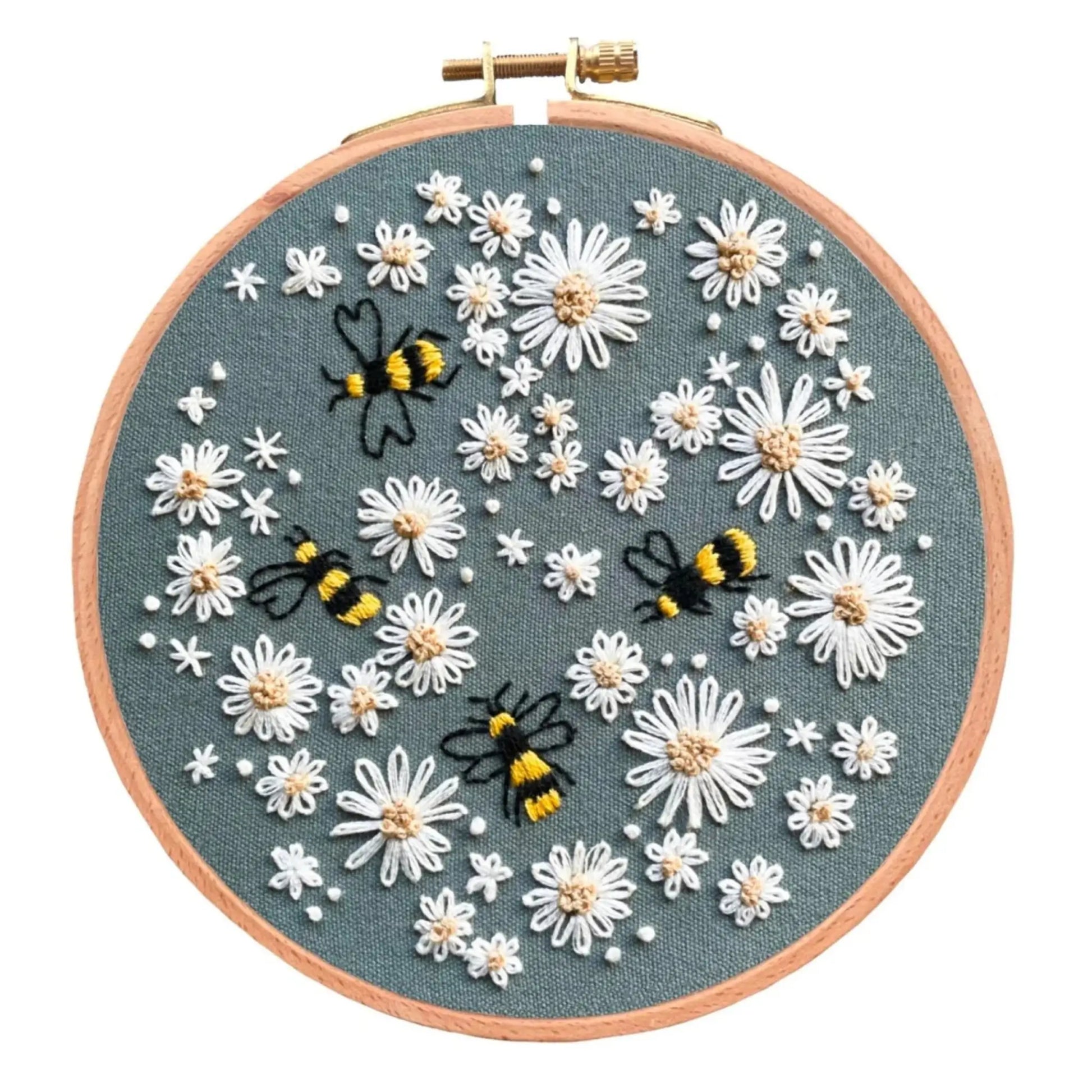 Embroidery hoop with floral and bee design on green fabric